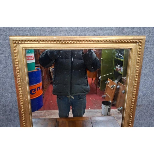 Antique Mirror with a Pearl Frieze in Gilded Wood – 19th Century Elegant antique mirror in molded and gilded wood,...