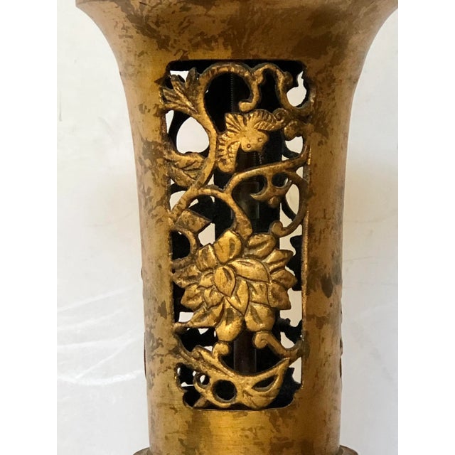 Beautifully pierced metal lamp with floral motif on the top and lower sections and a heavily etched band in the middle....