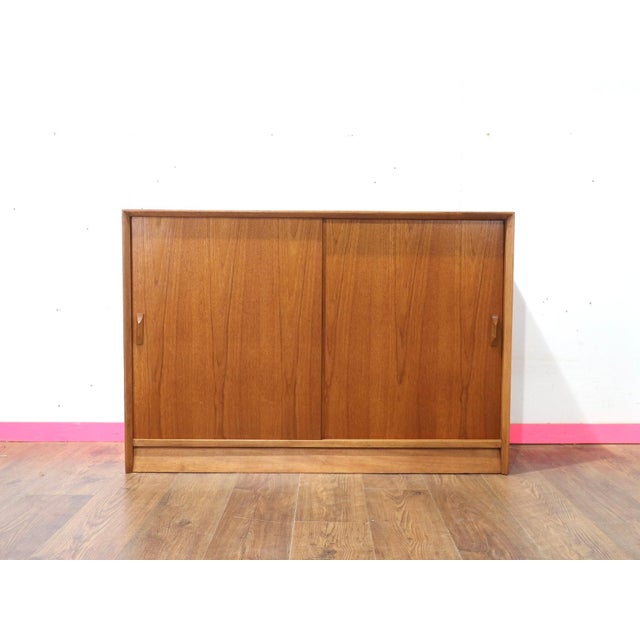 Discover the timeless elegance of our Mid Century Modern Vintage Teak Bookcase Display Cabinet in the style of renowned...