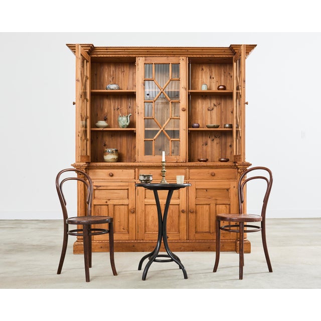 Amazing early 20th century French pine bookcase cabinet featuring astral glazed doors and neoclassical style corinthian...