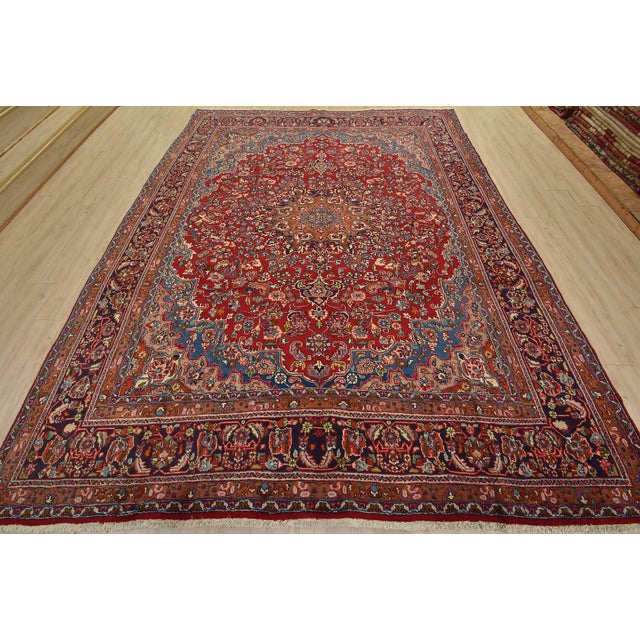 An authentic vintage traditional Mashad rug hand-knotted with fine wool and natural dyes. This rug features a central...