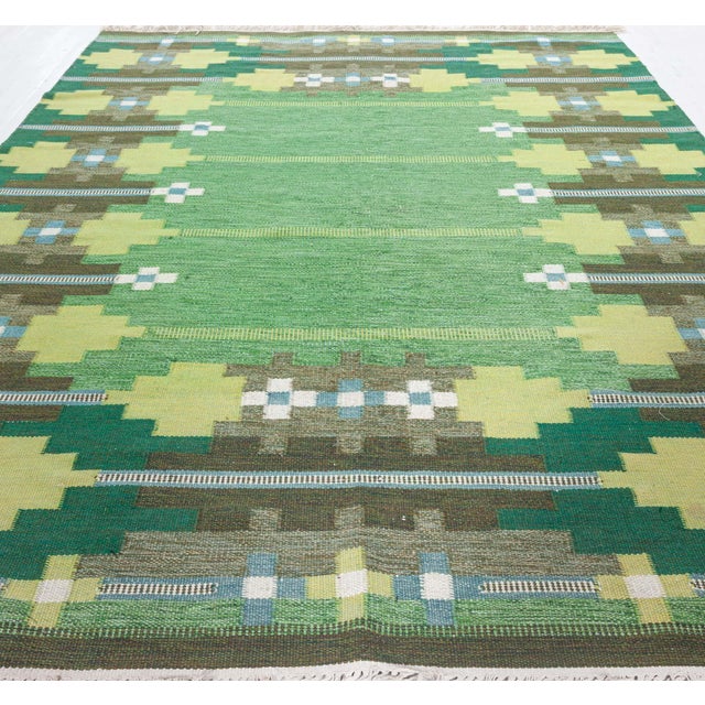 Vintage Swedish Flat-Weave Rug in Lush Greens and Geometric Patterns Size: 6'8" × 9'6" (203 × 289 cm) A vivid expression...