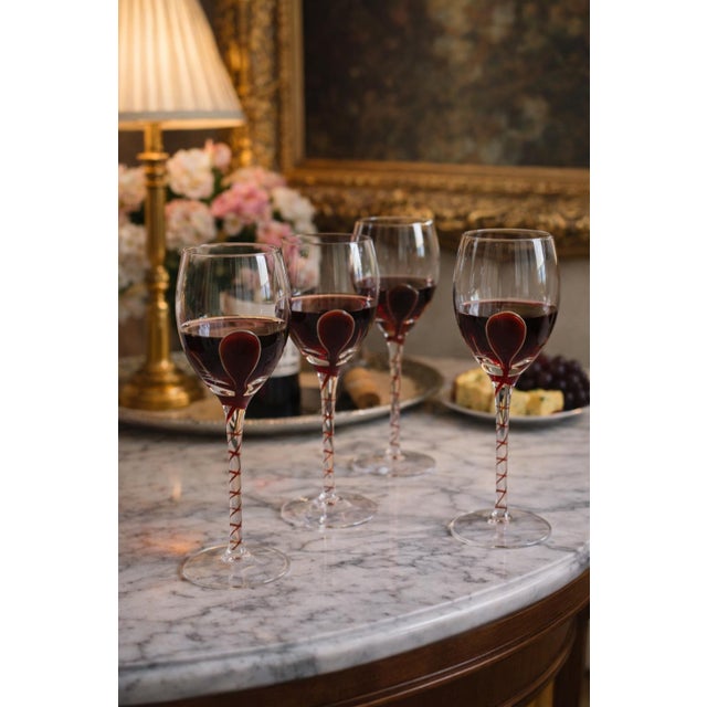 This set of 10 vintage wine goblets features clear glass bowls accented by decorative red spiral stems and sculptural red...