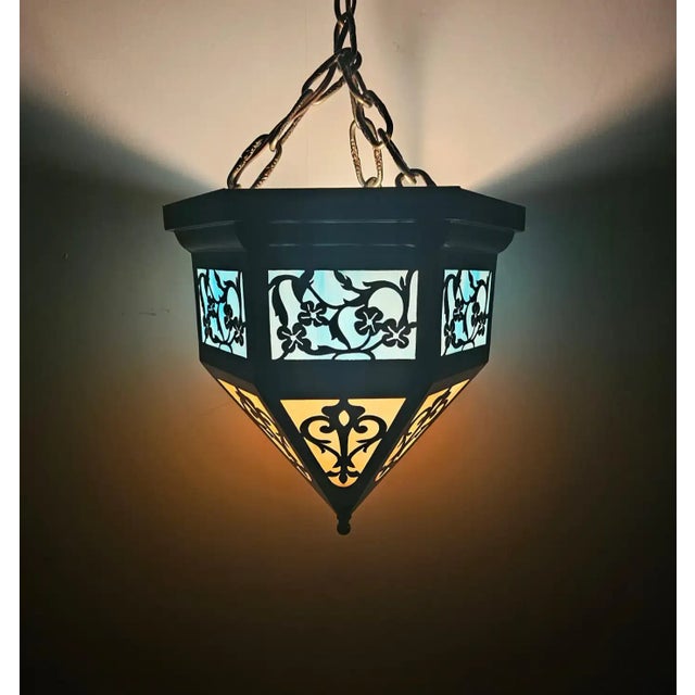 This pendant features an elegant hexagonal shape, tapering down to a sharp point, which emphasizes both balance and...