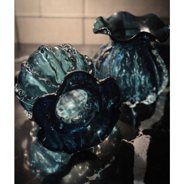 A sculptural pair of mid-century hand-blown teal glass vases, each with a dramatic ruffled rim and deep sommerso-style...