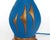 A vintage chalkware table lamp with an abstract sail-like raised decoration to the front and a hooped or ribbed neck,...
