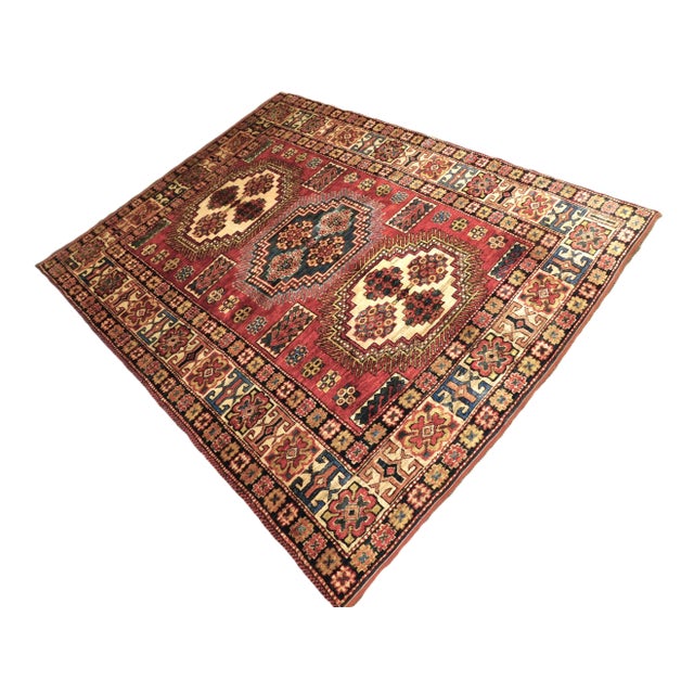 Three geometric shaped medallions on a scarlet background in Caucasian style. The rug is hand-knotted tribal style rug...