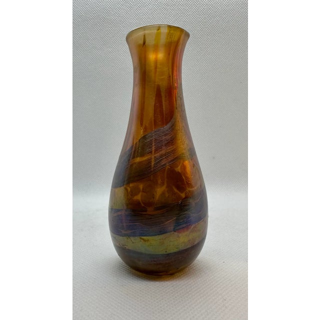 This little vase of burnished ambers, copper and bronze has an iridescent cast to it. The iridescence is the result of...