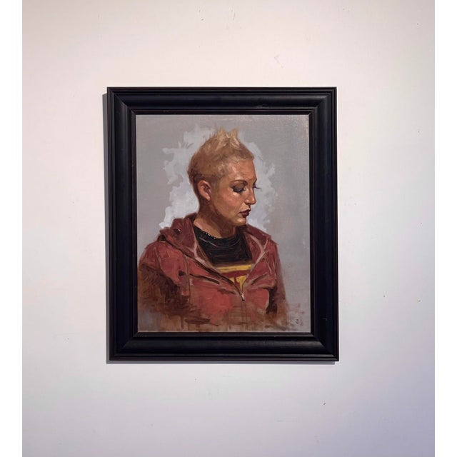 The artwork features a contemplative figure with a striking short hairstyle, dressed in a casual hoodie, creating an...
