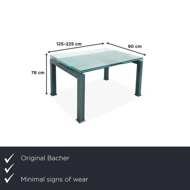 Modern dining table with a glass top and colored wooden frame. The tabletop measures 125 x 90 cm and can be extended on...