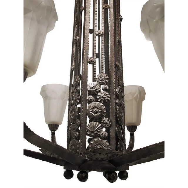 French Art Deco hand-forged wrought iron chandelier by the French artist " Degue ". Decorated in different textures with...