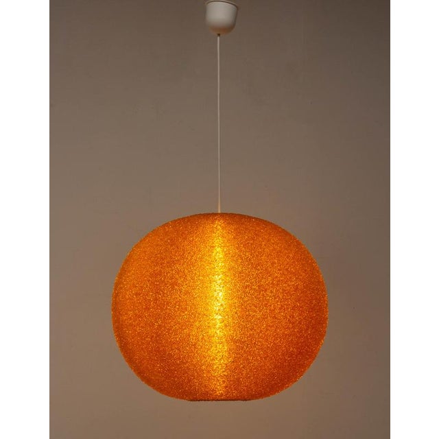 1970s Textured orange plexiglas pendant Light A beautiful spherical pendant light from the 1970s, featuring an orange...