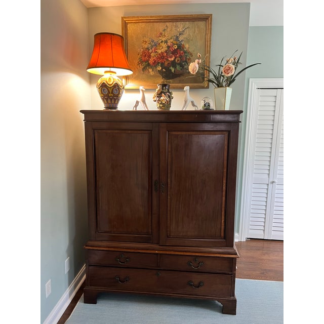 A handsome George II–style dwarf linen chest, crafted in a warm cherry finish with clean paneled doors and classic brass...