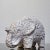 A stout figurine of a white elephant with a glossy translucent glaze revealing the red clay body underneath. Designed by...