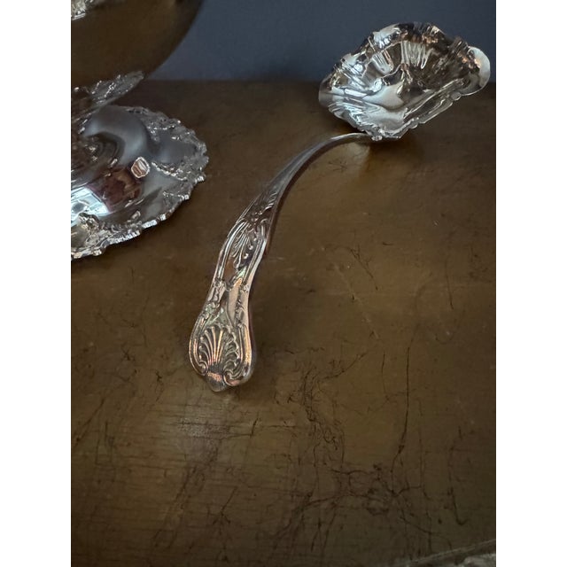 The set features an ornate, classic European style with a distinctive scalloped, wavy rim decorated with molded grapevine...
