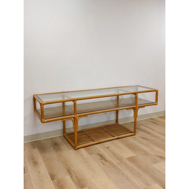This striking vintage rattan two-tier console table with glass tops is a beautifully crafted and generously proportioned...