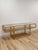 This striking vintage rattan two-tier console table with glass tops is a beautifully crafted and generously proportioned...