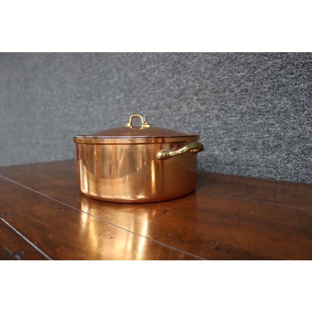 Copper stock pot with a fitted lid and solid brass side handles and lid pull. The interior is lined with stainless steel,...