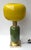 Pair of table or bedside lamps in brass, and green murano glass with yellow bulb globe shades. Contemporary work from a...