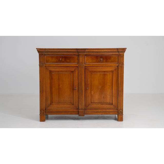 Rendered in rich golden oak, this French Louis XVI buffet exemplifies the neoclassical elegance that defined late...