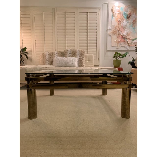 Beautiful Post Modern Brass and glass Coffee table in the style of Milo Baughman. Glass has a few minor scratches and...