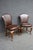 Pair of Theodore Alexander side chairs featuring brown leather upholstery, brass nailhead trim, and carved cherry frames...