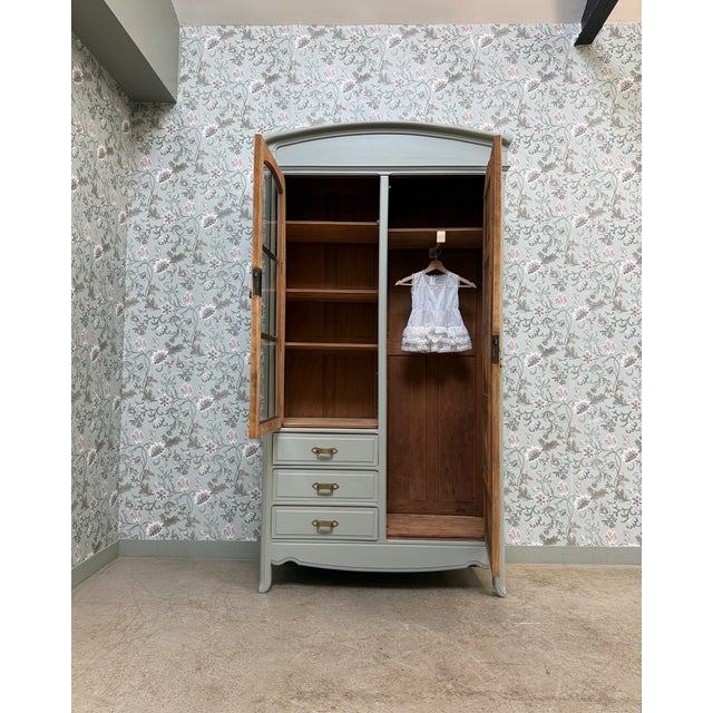This elegant art nouveau wardrobe captivates with its delicately curved lines, its glazed door with small panes, and its...