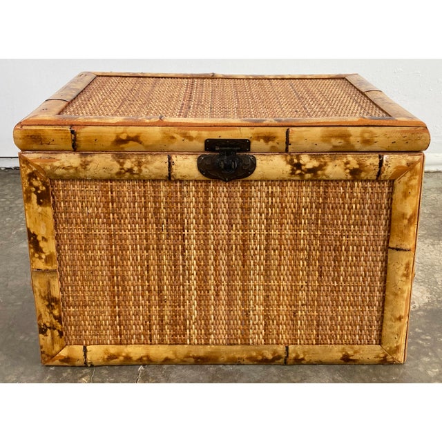 Vintage substantial scorched rattan edged trunk featuring caned surfaces on all sides. Metal closure with handles to both...