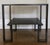 This contemporary end table features a sleek, Greek-key style iron frame with a rich bronze finish. The distinct geometric...