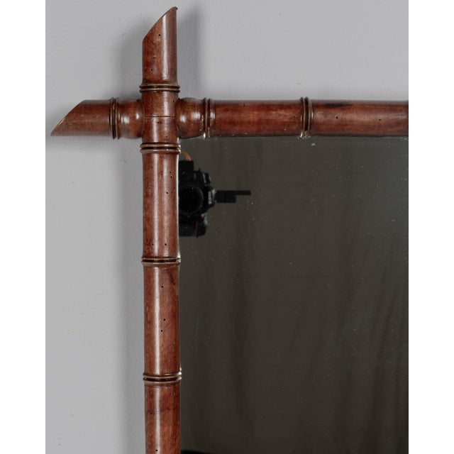 A French faux bamboo framed wall mirror made of turned cherry wood with waxed patina. Original mirror in good condition....