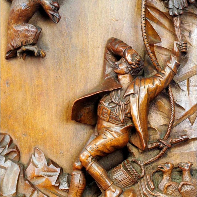 A fine wood carving relief depicting a scenery of a nest robbing of a raptor by a man. The model for this carving was...