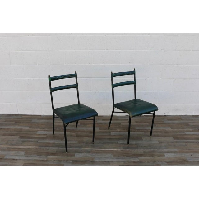 Stunning pair of original 1950s French chairs by Jacques Adnet, featuring beautifully aged green leather paired with...
