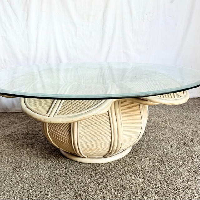 This vintage coastal coffee table features an elegant bellflower-inspired base crafted from reed and rattan. Its...