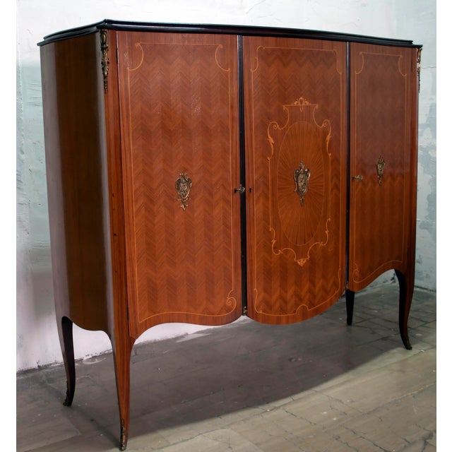 This rosewood and cottonwood bar cabinet was manufactured in the 1950s. This piece has an attribution mark, I am sure that...