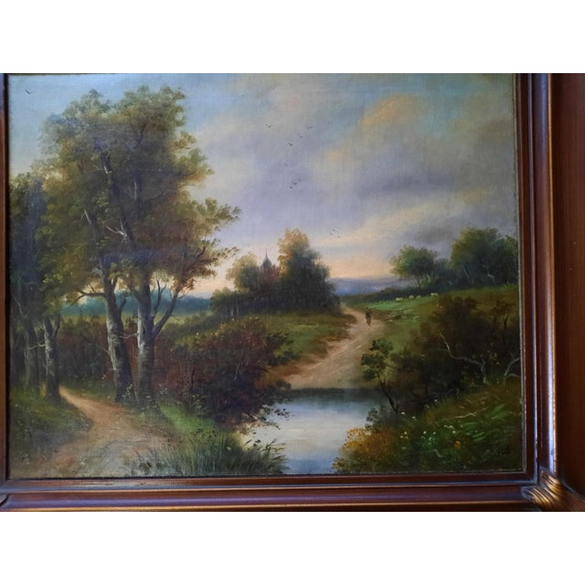 A charming and finely detailed antique oil on canvas painting featuring a classic European pastoral landscape. The serene...