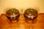 A pair of antique Chinese lacquered wooden lidded storage vessels with rounded black lacquer bodies, slightly domed lids...