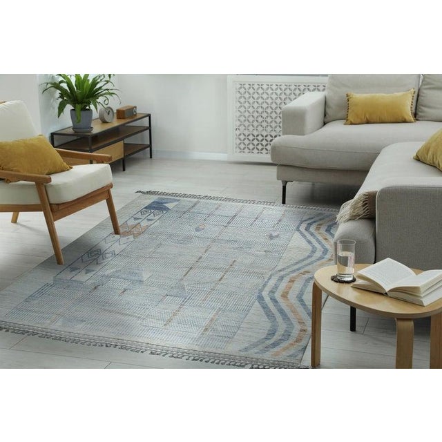This gray wool rug features a hand knotted pile weave, characteristic of the Berber carpet style. Crafted in Pakistan,...