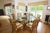 A large hexagonal McGuire style glass top dining table with a large geometric bamboo base with six legs connected by a...