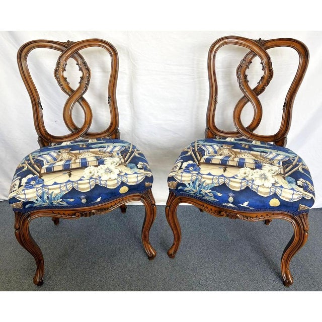 Pretty pair of vintage pretzel back chairs from the early 20th century. These solid wood chairs have a ribbon or pretzel...