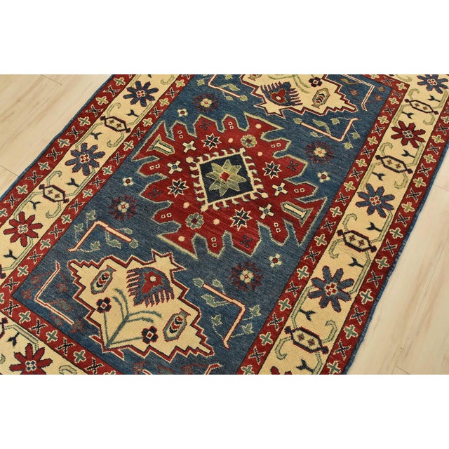 A tribal Caucasian Kazak rug hand-knotted with fine wool on a cotton foundation. This oriental rug features geometric...