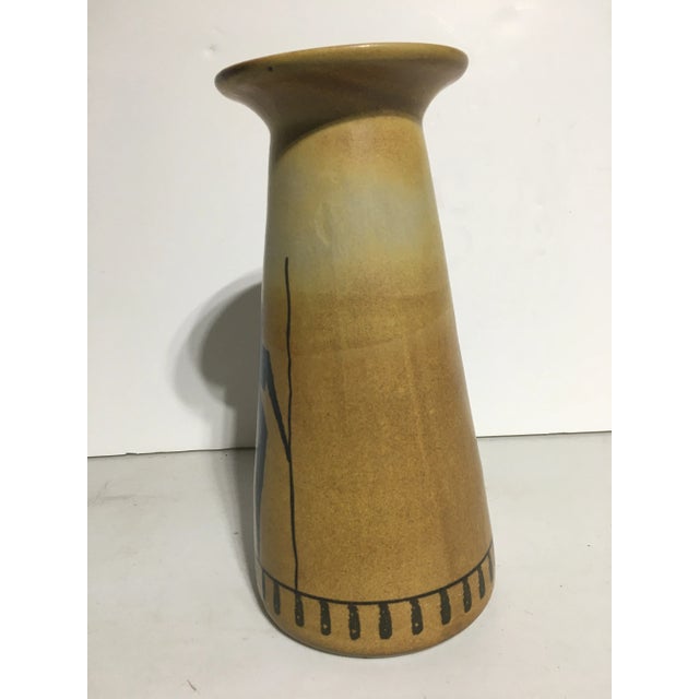 This vase has a male &female figure With long spears as the figural decoration on the pottery Excellent condition