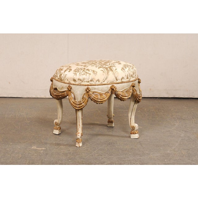 A vintage Italian carved and painted wood stool with upholstered seat. This stool from Italy, circa 1970's, has an oval...