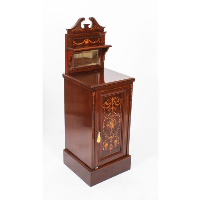 A pair of Edwardian mahogany and marquetry inlaid Sheraton-revival bedside cabinets, the swan-neck pediments above a small...