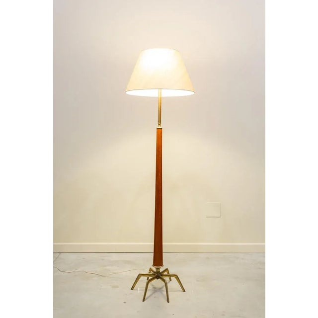Floor lamp with two lights and lampshade. It consists of gilded bronze base with six small legs arranged in a circular...