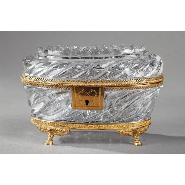 Exquisite oval-shaped cut-crystal antique jewelry box. The crystal is chiseled into twisted patterns, and the mounts are...