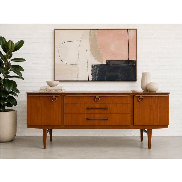 Mid Century Modern Teak Sideboard by Elliots of Newbury, Made in England, c. 1960’s showcasing clean lines and exceptional...