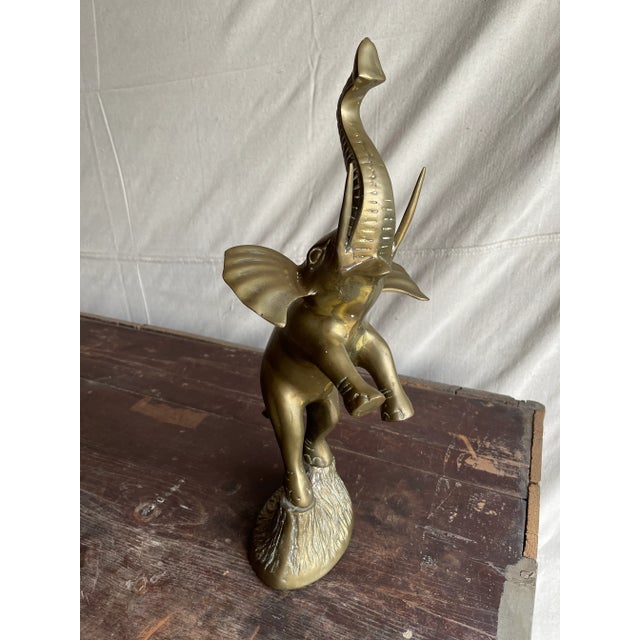 A beautiful vintage figurine brass elephant born in Korea circa 1960. Standing on top of a pedestal this pachyderm reaches...