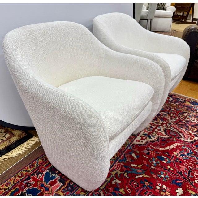 Striking the perfect balance between sculptural form and cozy comfort, this pair of Mid-Century Modern style club chairs...