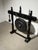 Striking freestanding metal gong suspended within an elaborately carved wooden frame. The dark-finished stand features...
