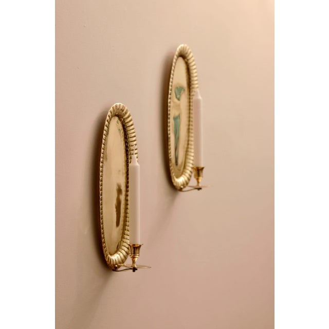 Made in Sweden Pair of exquisite repoussé Swedish brass wall sconces showcasing captivating hammered style. Meticulously...